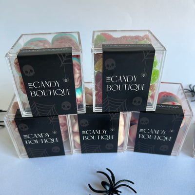 Candy boxes with Halloween-themed packaging with spider decorations and assorted gummy candy