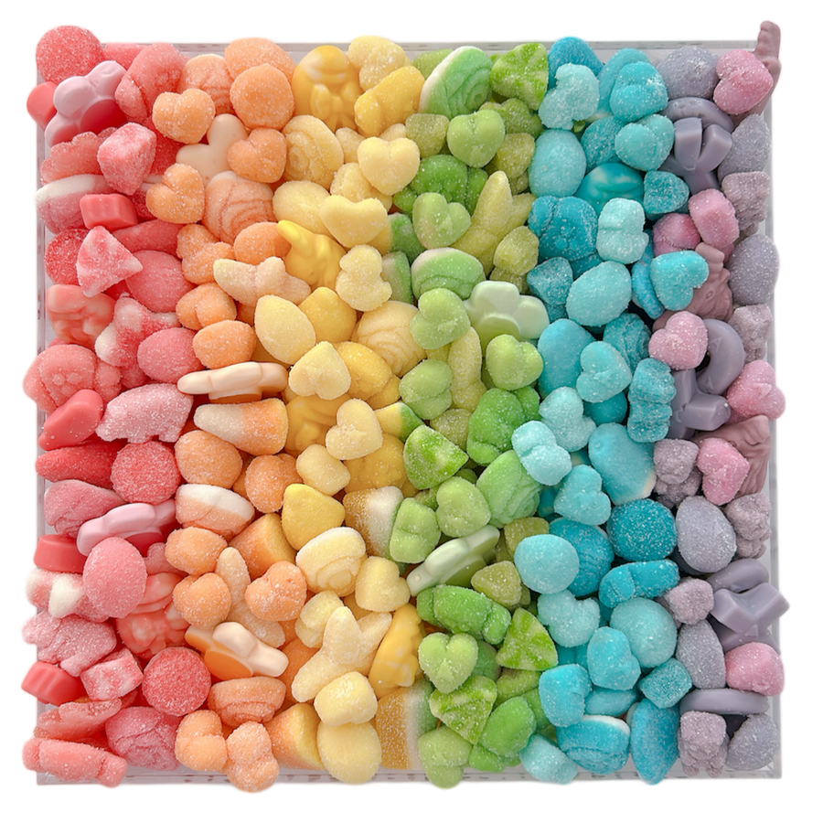 Colorful pastel gummy candy arranged in a rainbow pattern in an acrylic tray