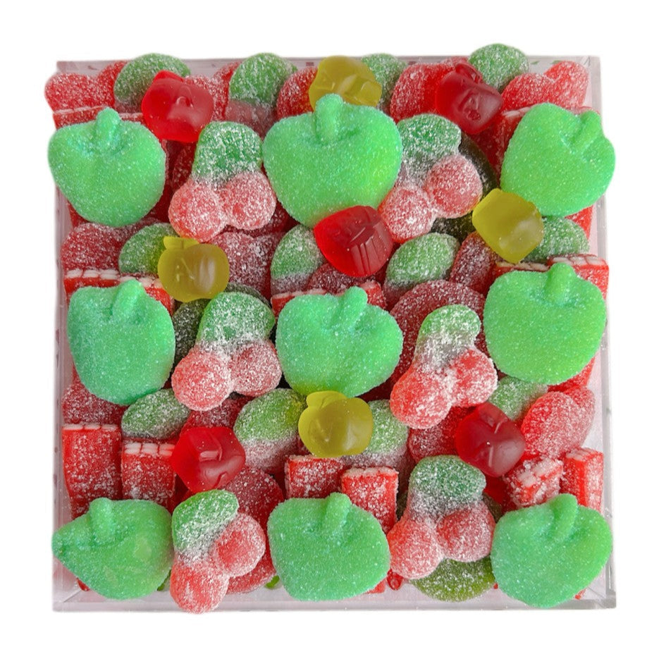Assorted fruit gummies including green apple, red apple, shapes in an acrylic tray