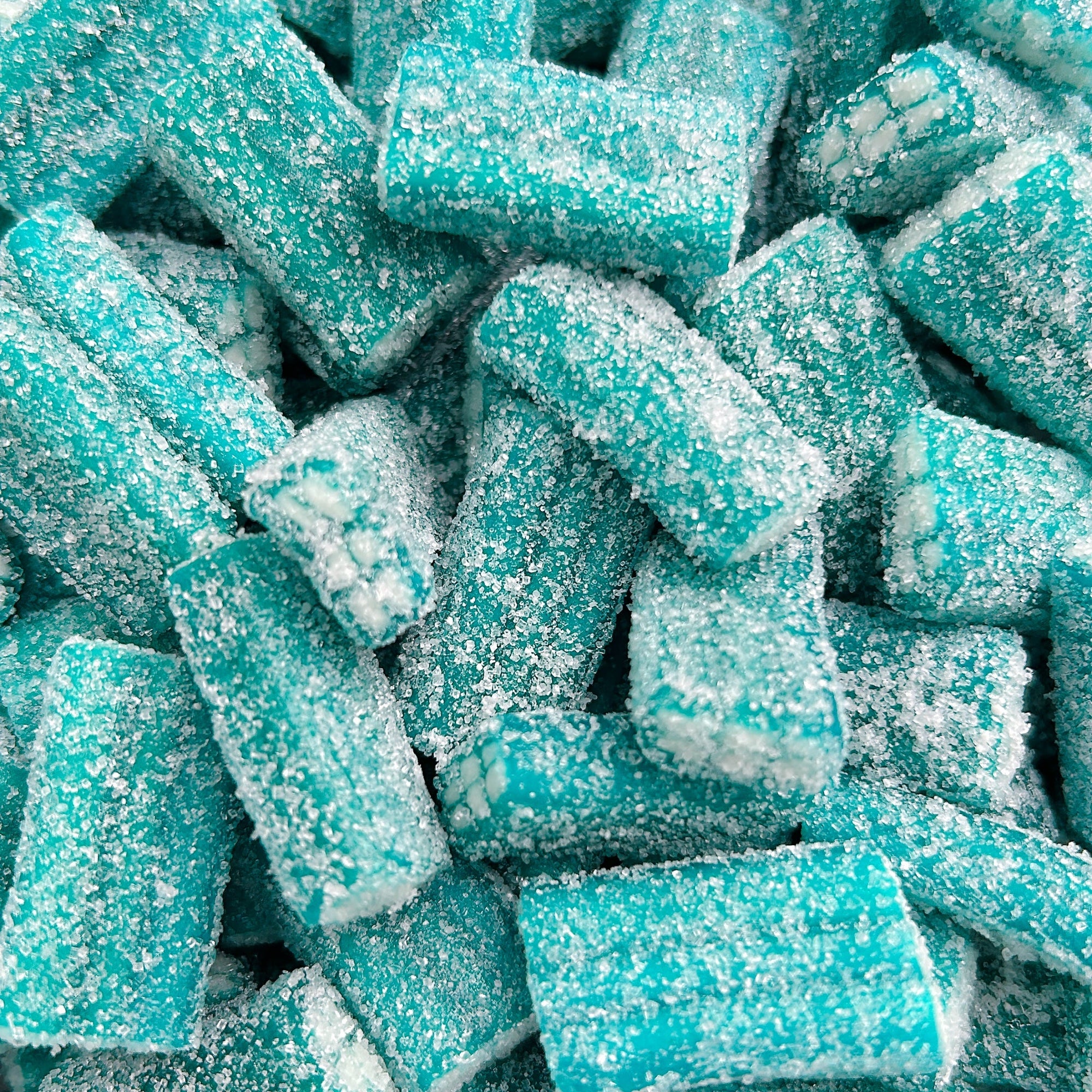A close-up pile of blue rectangular candies coated in white sugar crystals