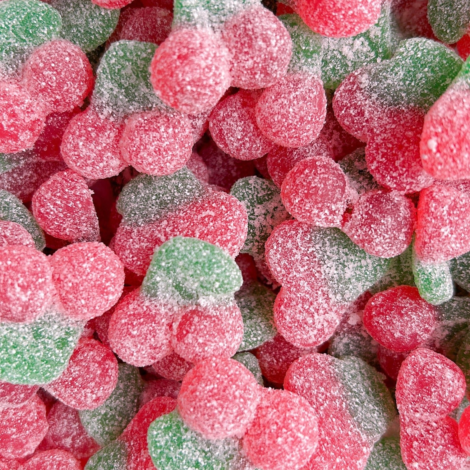 Close-up of red cherry gummies covered in sweet and sour sugar